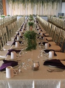 Long wedding table lined with dishes and cutlery
