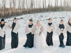 Bride with Bridesmaids in a row behind her outside in winter