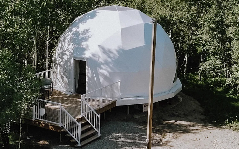 A sphere shaped white house. This house is called Wanderlust Domes