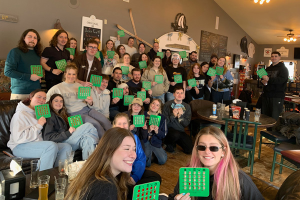 A large group of people holding up green bingo cards.