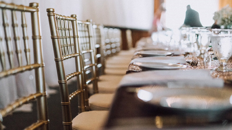 A closeup photo of a gold table decorated for a wedding.